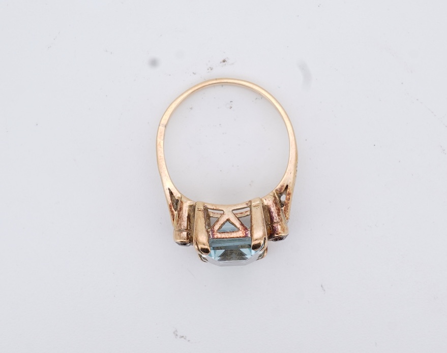 A yellow metal and single stone emerald cut aquamarine set ring, with two stone diamond set shoulders, size M, gross weight 4.2 grams.